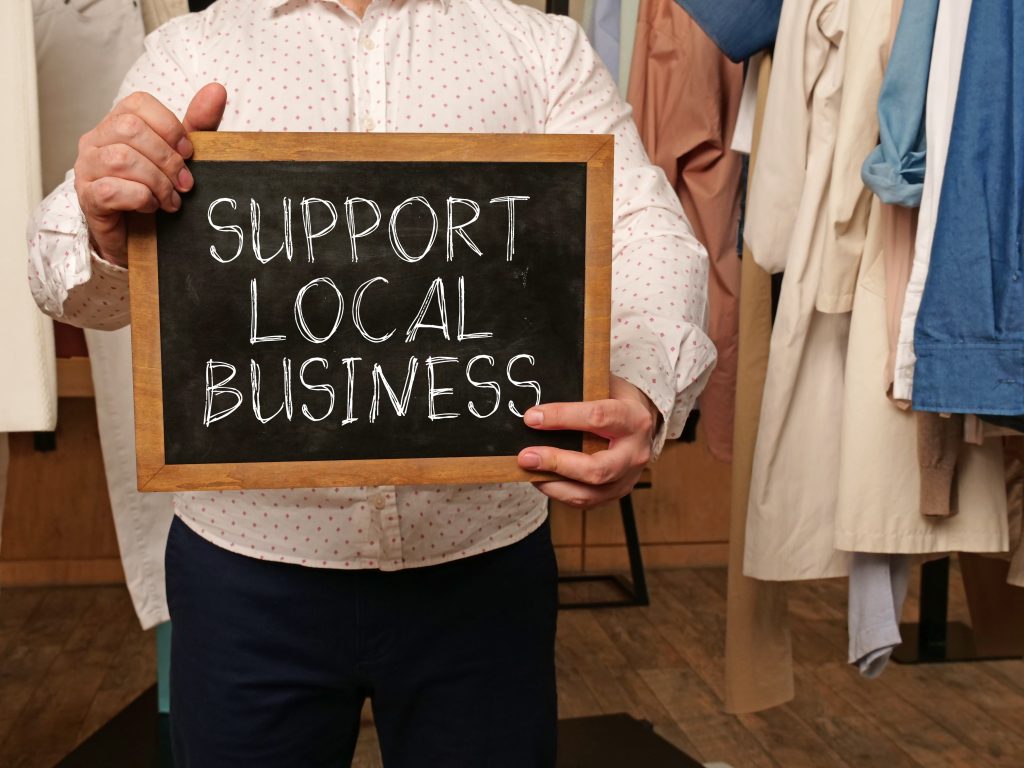 Support local business is shown using a text on a board held by a businessman