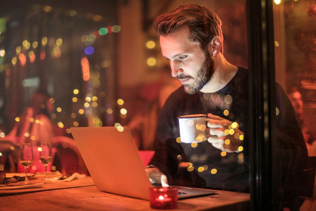 Male accountant working on a cafe while drinking coffee