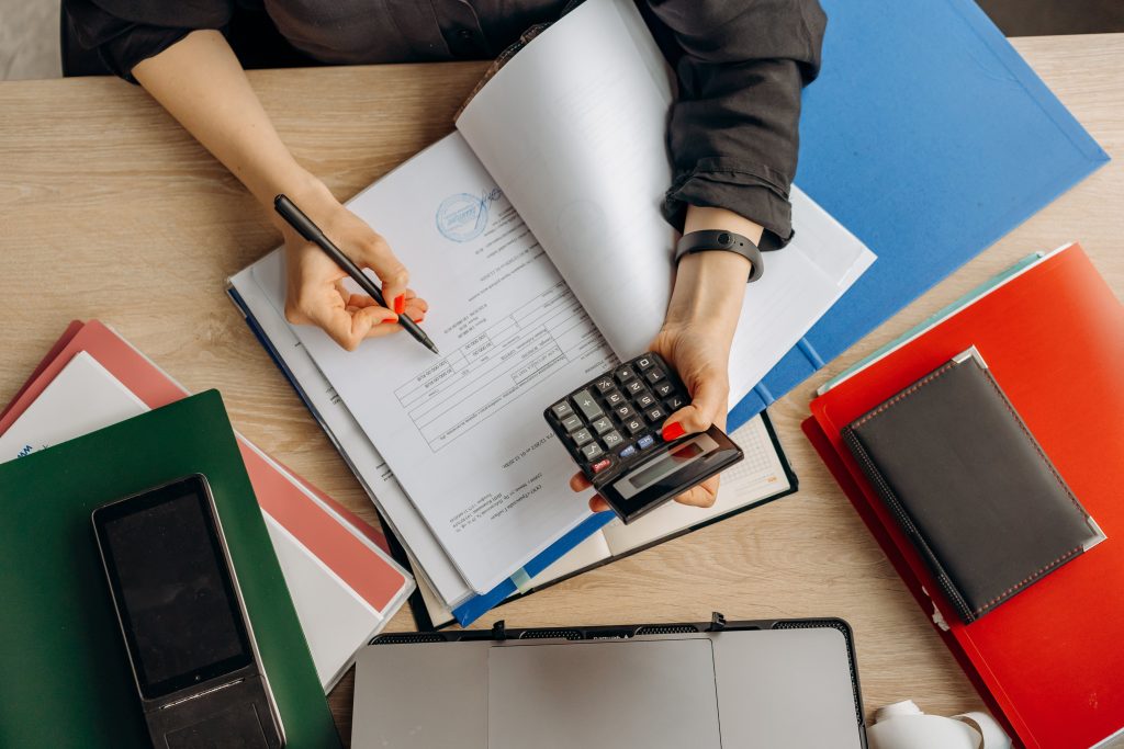 accountant computing tax returns for a client using a calculator