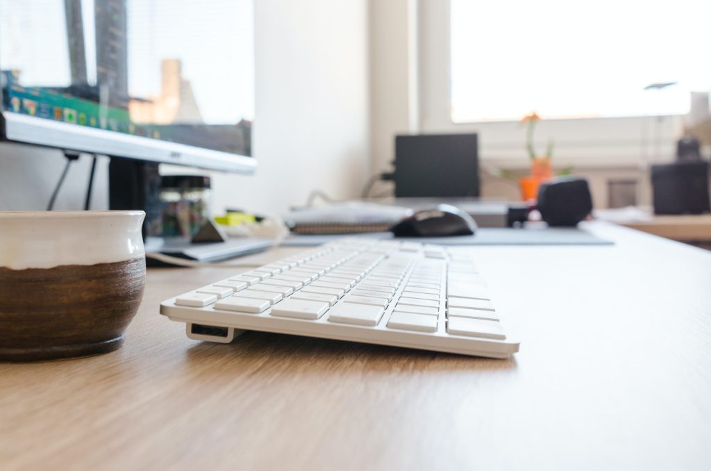 white keyboard on top of a wooden table