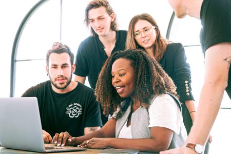 Accountants having a meeting while the accountant near the laptop is smiling