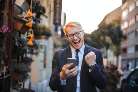 accountant that is happy and motivated while checking his phone