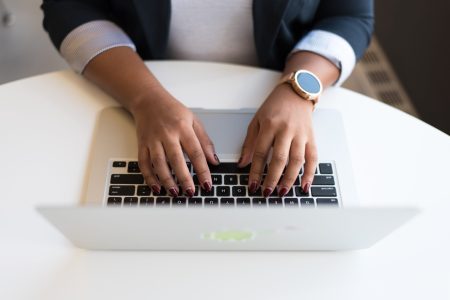 top view photo of an accountant typing on her macbook