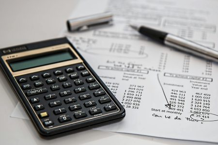 calculator and pen on top of a printed tax return